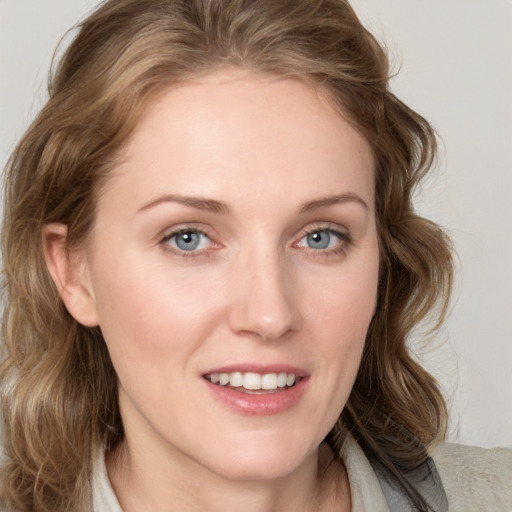 Joyful white young-adult female with medium  brown hair and blue eyes