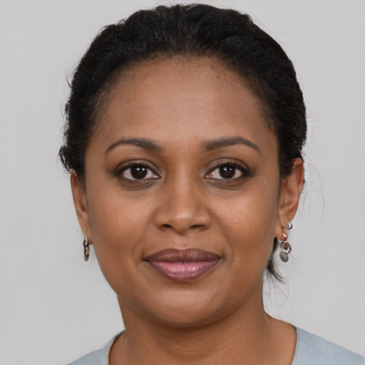 Joyful black young-adult female with short  brown hair and brown eyes