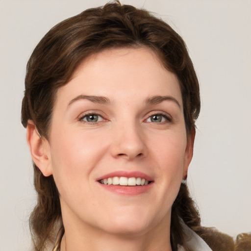 Joyful white young-adult female with medium  brown hair and grey eyes