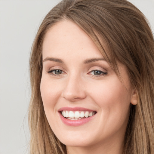 Joyful white young-adult female with long  brown hair and grey eyes