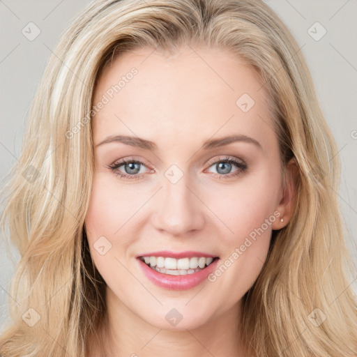 Joyful white young-adult female with long  brown hair and blue eyes