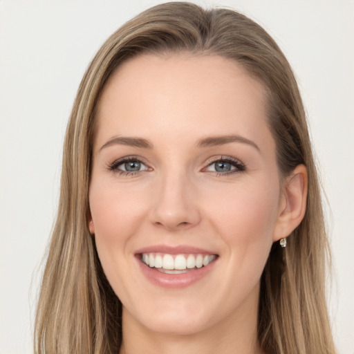 Joyful white young-adult female with long  brown hair and blue eyes