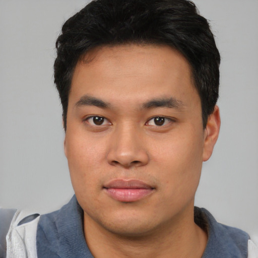 Joyful asian young-adult male with short  black hair and brown eyes