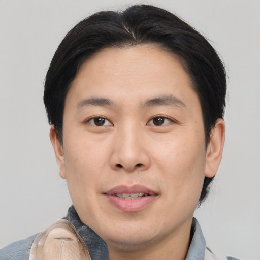 Joyful asian young-adult male with short  brown hair and brown eyes
