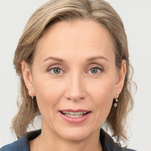 Joyful white adult female with medium  brown hair and grey eyes