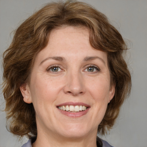 Joyful white adult female with medium  brown hair and grey eyes