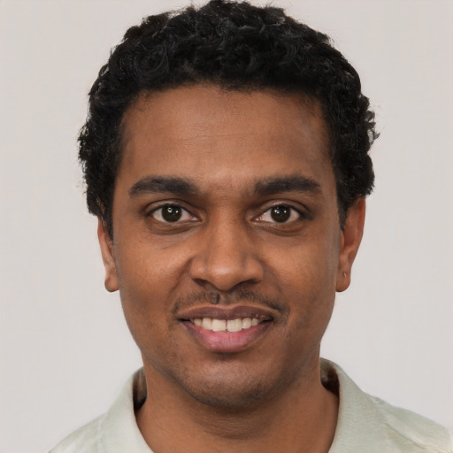 Joyful black young-adult male with short  black hair and brown eyes