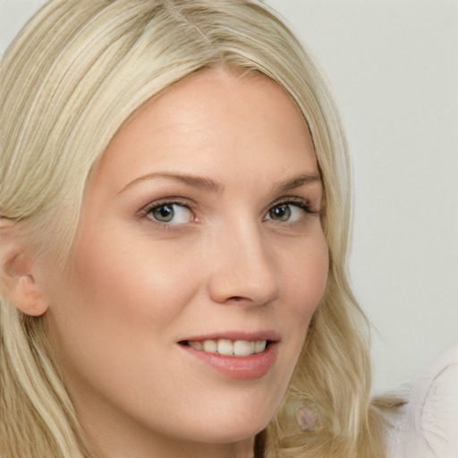 Joyful white young-adult female with long  blond hair and blue eyes