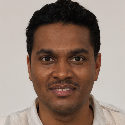 Joyful black young-adult male with short  black hair and brown eyes