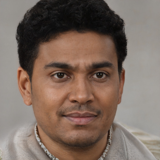 Joyful latino young-adult male with short  brown hair and brown eyes