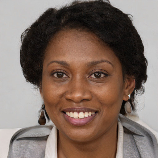 Joyful black adult female with medium  brown hair and brown eyes