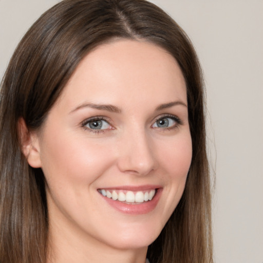 Joyful white young-adult female with long  brown hair and brown eyes