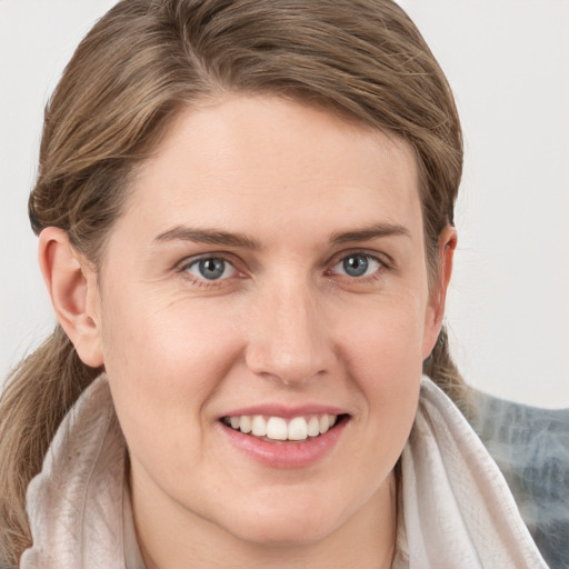 Joyful white young-adult female with medium  brown hair and grey eyes