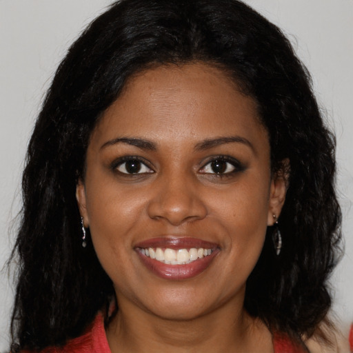 Joyful black young-adult female with long  black hair and brown eyes