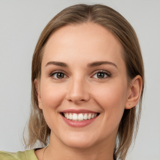 Joyful white young-adult female with medium  brown hair and grey eyes