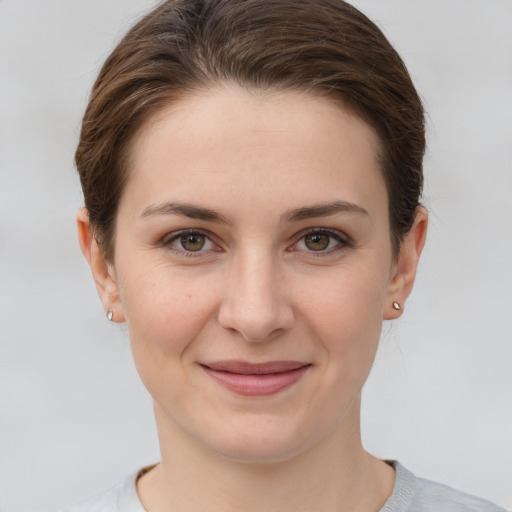 Joyful white young-adult female with short  brown hair and grey eyes