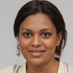 Joyful black young-adult female with medium  brown hair and brown eyes