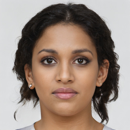 Joyful latino young-adult female with medium  brown hair and brown eyes