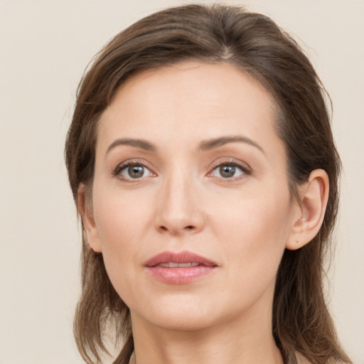 Joyful white young-adult female with long  brown hair and grey eyes