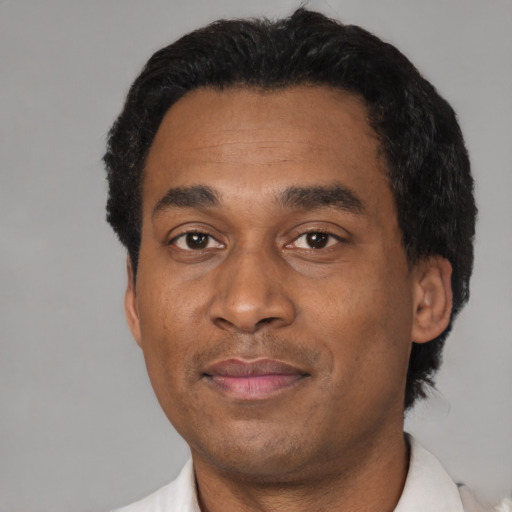 Joyful latino adult male with short  black hair and brown eyes