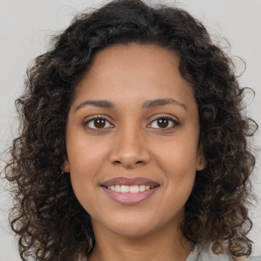 Joyful latino young-adult female with long  brown hair and brown eyes