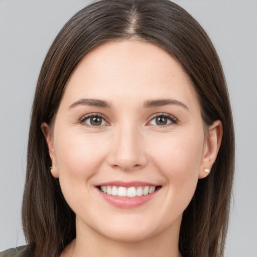 Joyful white young-adult female with long  brown hair and brown eyes