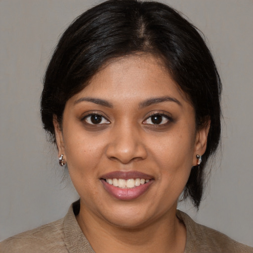 Joyful black young-adult female with medium  brown hair and brown eyes