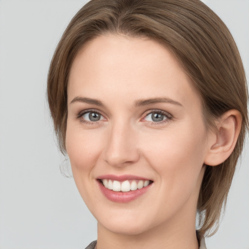 Joyful white young-adult female with long  brown hair and grey eyes