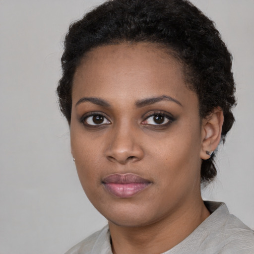Joyful black young-adult female with short  black hair and brown eyes