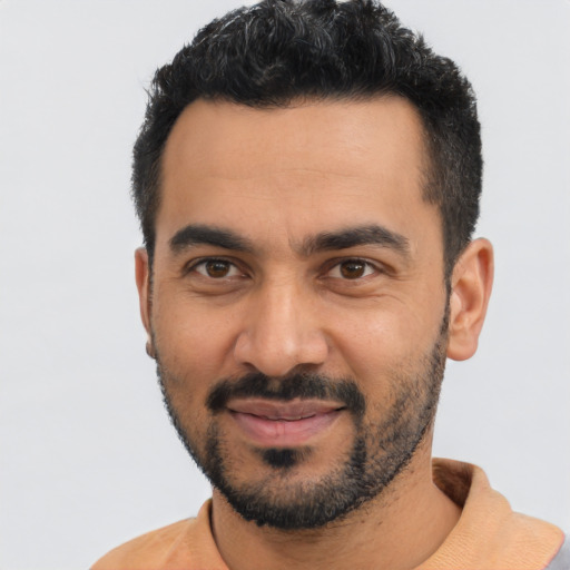 Joyful latino young-adult male with short  black hair and brown eyes