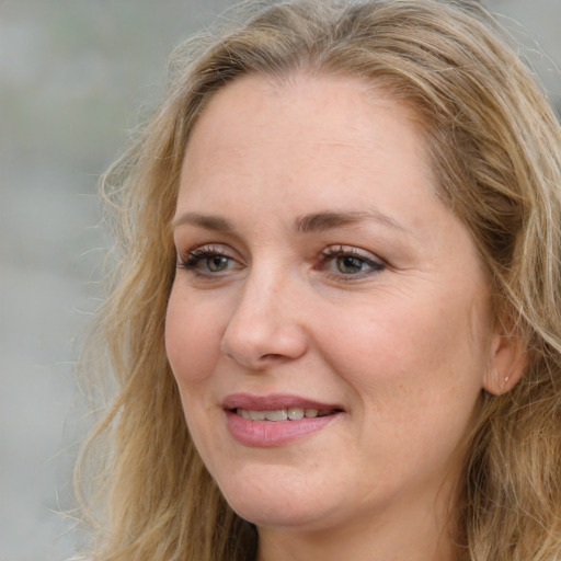 Joyful white adult female with medium  brown hair and blue eyes