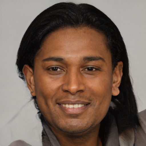 Joyful black adult male with medium  black hair and brown eyes