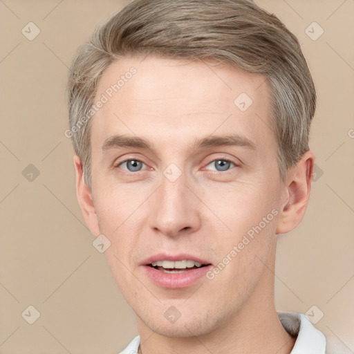 Joyful white young-adult male with short  brown hair and grey eyes