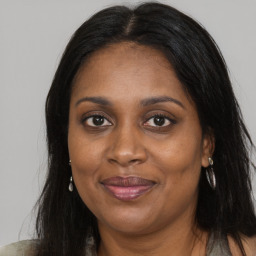 Joyful black adult female with long  brown hair and brown eyes