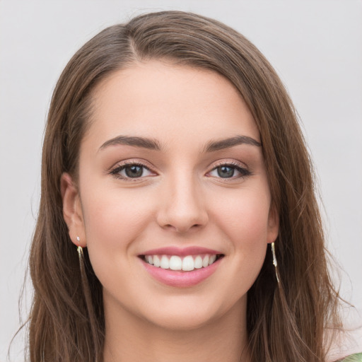 Joyful white young-adult female with long  brown hair and green eyes