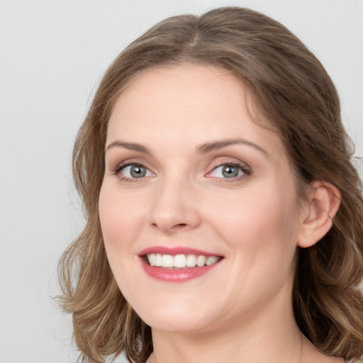 Joyful white young-adult female with long  brown hair and green eyes