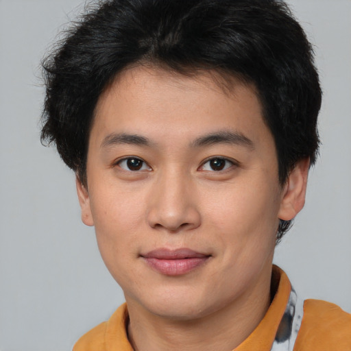 Joyful asian young-adult male with short  brown hair and brown eyes