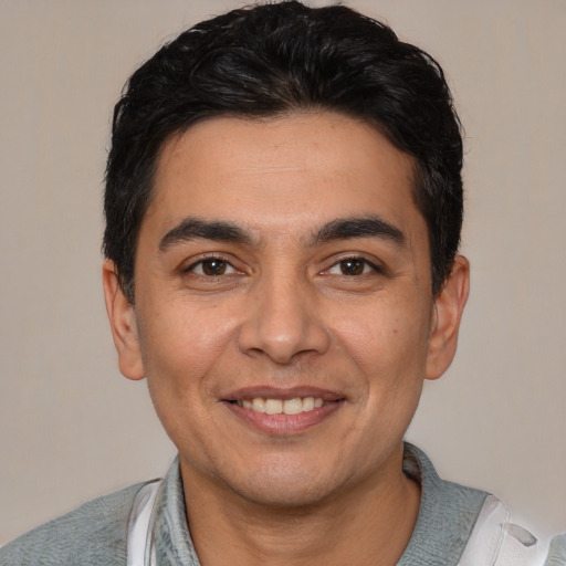 Joyful white young-adult male with short  black hair and brown eyes