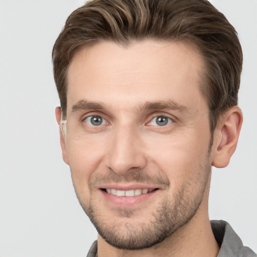 Joyful white adult male with short  brown hair and grey eyes