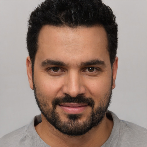 Joyful white young-adult male with short  black hair and brown eyes
