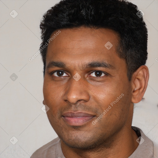 Joyful black young-adult male with short  black hair and brown eyes