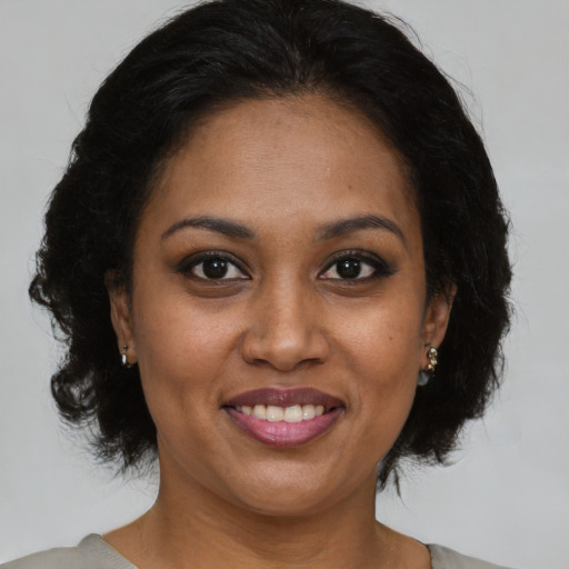 Joyful black adult female with medium  brown hair and brown eyes