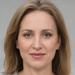 Joyful white adult female with long  brown hair and grey eyes