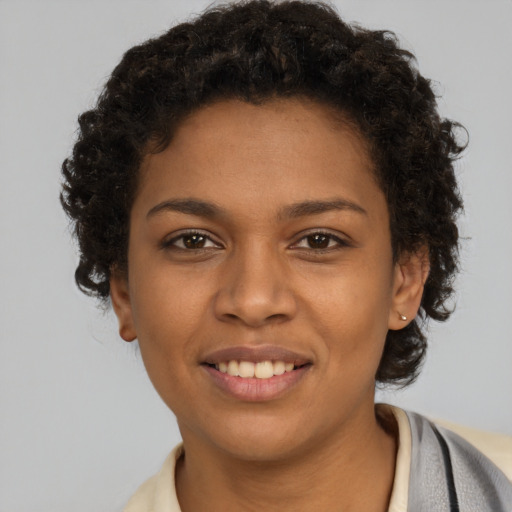 Joyful black young-adult female with short  brown hair and brown eyes