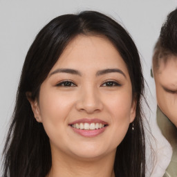 Joyful asian young-adult female with long  brown hair and brown eyes