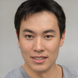 Joyful asian young-adult male with short  brown hair and brown eyes