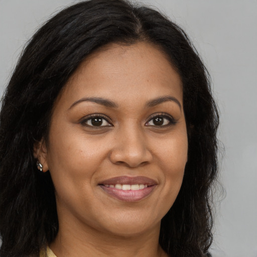 Joyful black young-adult female with long  brown hair and brown eyes