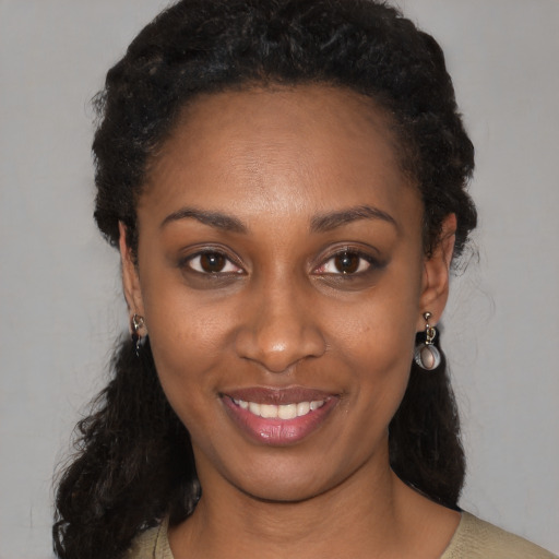 Joyful black young-adult female with medium  brown hair and brown eyes