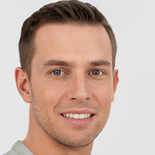 Joyful white young-adult male with short  brown hair and grey eyes