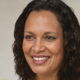 Joyful black adult female with long  brown hair and brown eyes